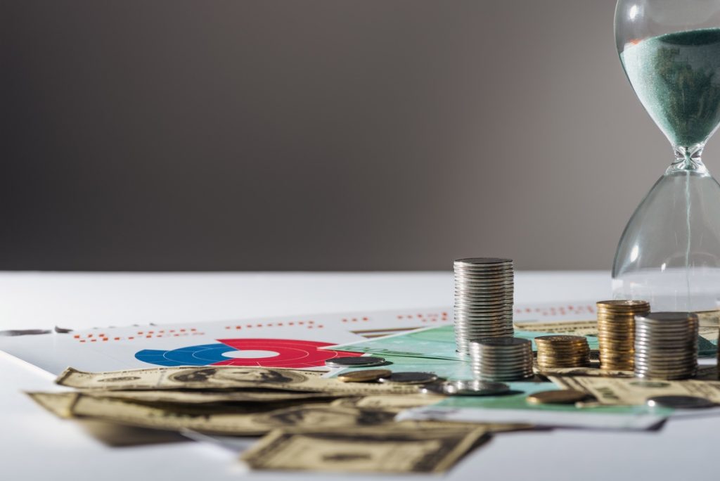 selective-focus-of-coins-stacks-hourglass-on-doll-2023-11-27-05-29-29-utc (1)